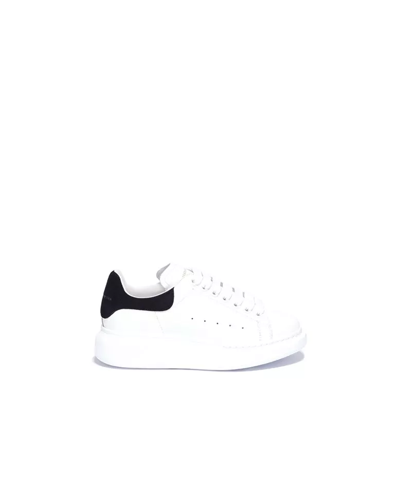 Alexander McQueen black suede heel counter oversized sneakers side in a full white back ground