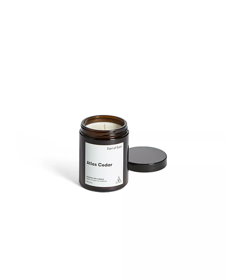 Earl of East Altas Cedar scented candle opened with cap beside front in a full white background