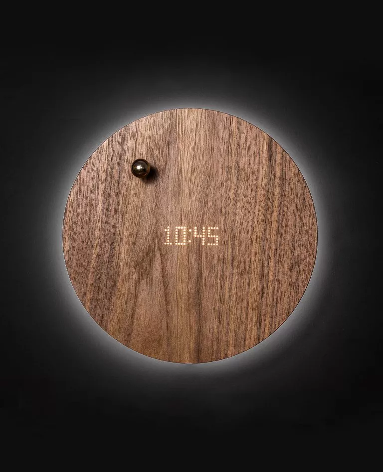 Flyte Story floating clock at 10:45 time with a chrome sphere hovering upon it lightened by LED back display in a full black background