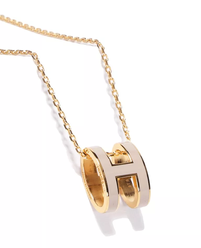Hermes pop h pendant milk tea and gold hardware details in a full white background