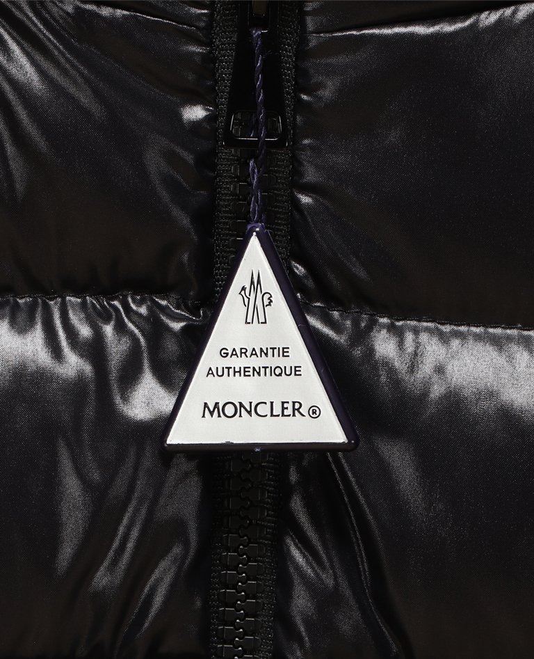 전체 흰색 배경에 정품 보증 태그 디테일이 있는 Moncler Bady 다운 재킷