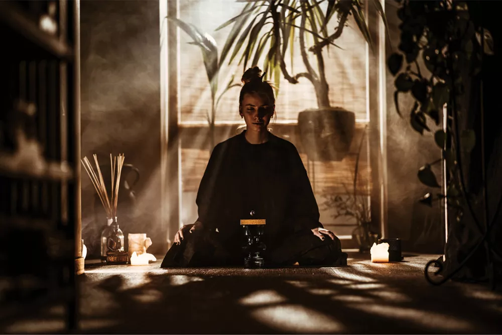 禅スタイルの部屋で瞑想する人とブダ ボール