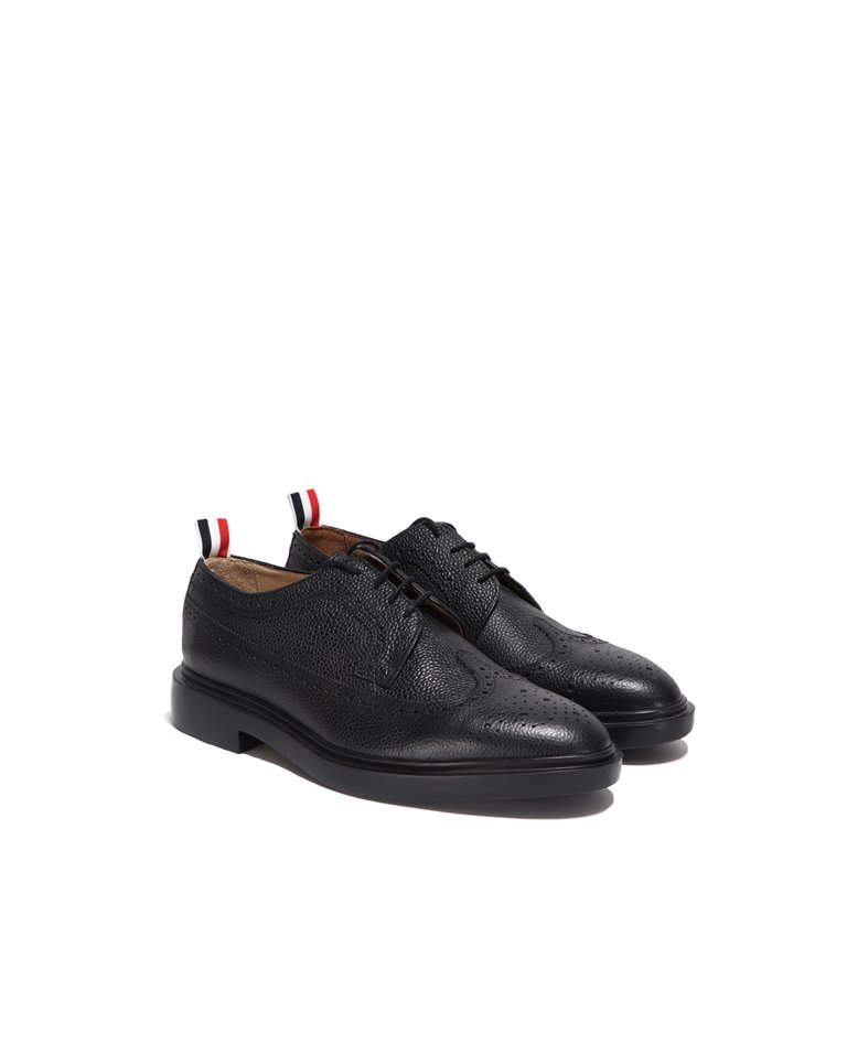 Thom Browne black classic longwing brogue with leather sole front in a full white background